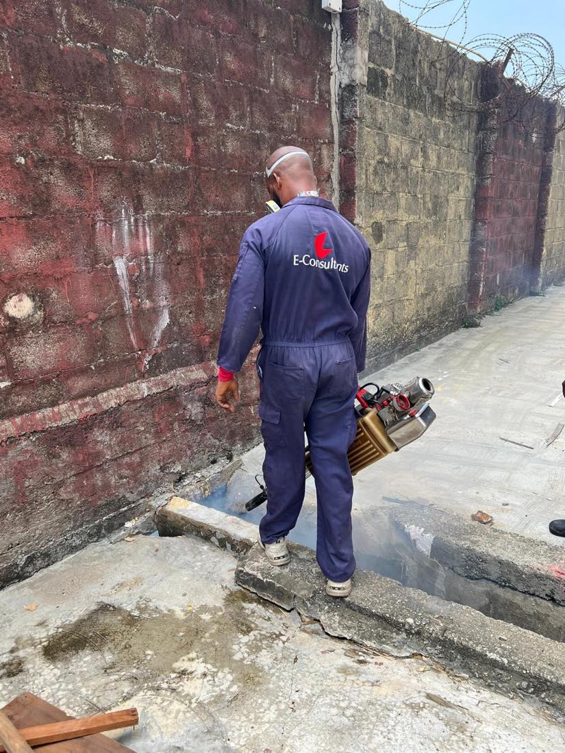 E Consultants technician in protective equipment treating a property in Lagos